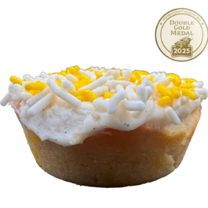 Lemon sugar cookie with yellow frosting, lemon zest, vanilla bean specks, and multicolored sprinkles on top.