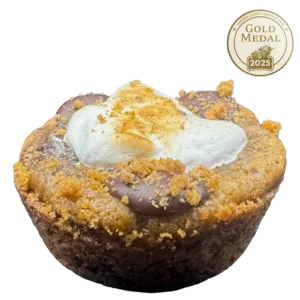 Gourmet S'mores cookie with a thick dough base, melted chocolate, graham cracker pieces, whipped peanut butter, and toasted honey marshmallow fluff, topped with mini peanut butter cups and salt flakes.